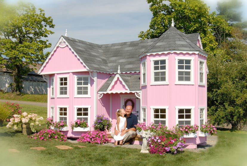Founder and daughter in front of pink Sara's Victorian Mansion playhouse.