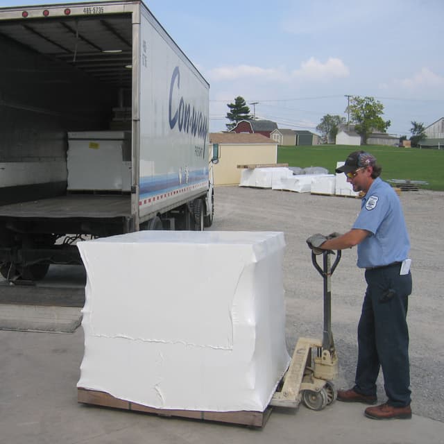 Packaged playhouse kit being lifted by a pallet jack.