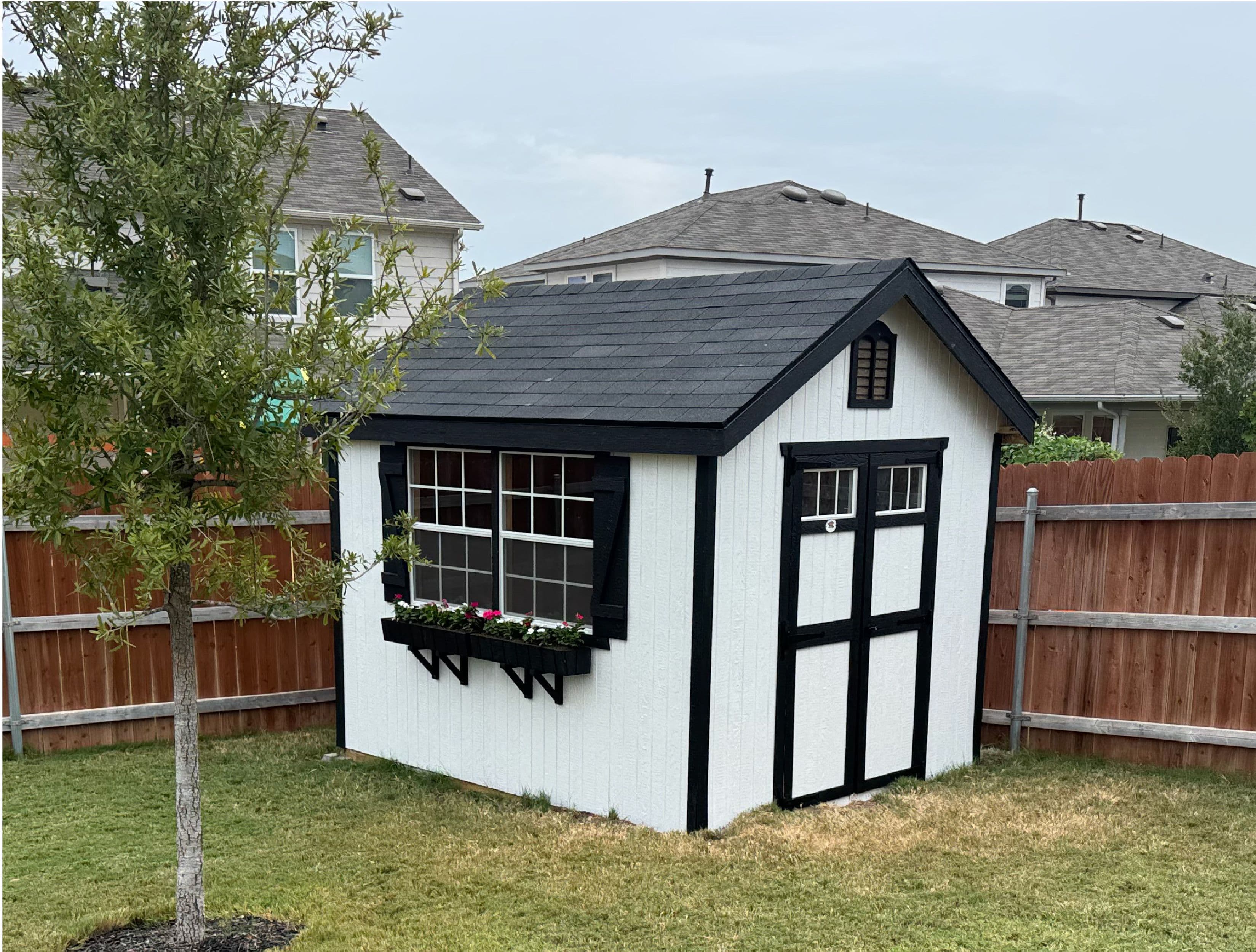 white and black wood shed with windows