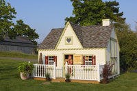 10x12 Victorian Playhouse with deck and rail and child leaning out door with stuffed animal