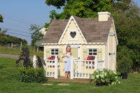 6x8 Victorian Playhouse with deck and rail and child holding stuffed animal in front